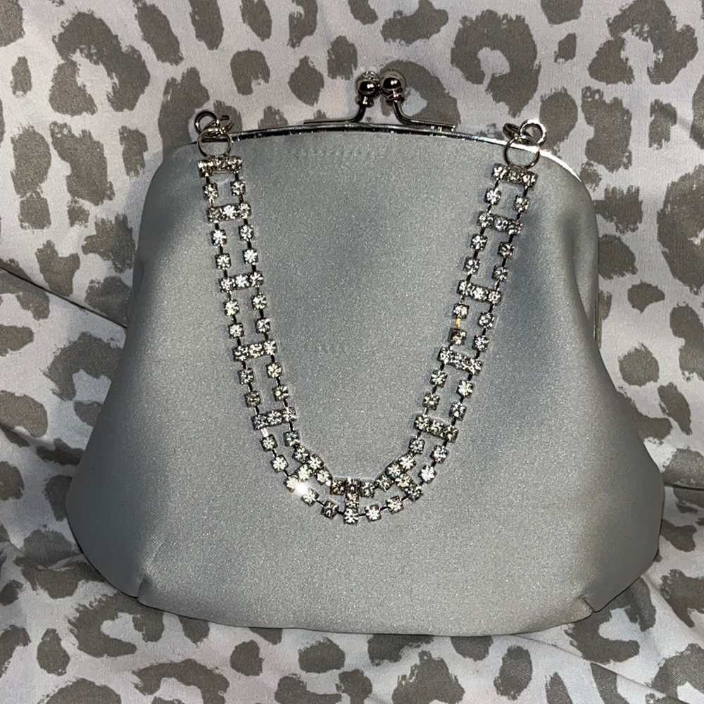 Small silver party clutch with rhinestone handle and clasp closure